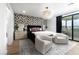 Bedroom featuring modern light fixture, wallpapered accent wall, and patio access at 11990 Montague St, Las Vegas, NV 89138
