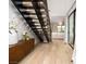 Hallway with modern staircase, hardwood floors, and view of the open-plan living space, creating an inviting atmosphere at 11990 Montague St, Las Vegas, NV 89138