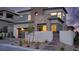Contemporary two-story home featuring a stone accent wall and a well-manicured front yard at dusk at 11990 Montague St, Las Vegas, NV 89138