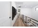 Bright hallway featuring wood floors, modern art, and railing overlooking living room at 11990 Montague St, Las Vegas, NV 89138