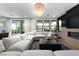 Bright living room with fireplace, stylish light fixture, and a comfortable sectional sofa, opening to the backyard at 11990 Montague St, Las Vegas, NV 89138