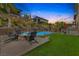Beautiful backyard with a fire pit, lawn, and pool is perfect for entertaining at 12356 Notch Trail Ave, Las Vegas, NV 89138