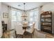 Charming dining room with a round wood table, elegant chandelier, and abundant natural light at 12356 Notch Trail Ave, Las Vegas, NV 89138
