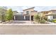 Contemporary home exterior features a three-car garage, desert landscaping and stone accents at 12356 Notch Trail Ave, Las Vegas, NV 89138