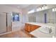 Bright bathroom with dual sinks, soaking tub, and glass door shower at 2585 Portsmouth Creek Ave, Henderson, NV 89052