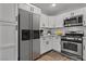White kitchen featuring stainless steel appliances, white cabinets, and wood-look flooring at 2851 S Valley View Blvd # 1098, Las Vegas, NV 89102