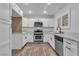Modern white kitchen featuring stainless steel appliances and wood-look floors at 2851 S Valley View Blvd # 1098, Las Vegas, NV 89102