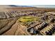 Expansive aerial view of a residential community with a central park, mountains in the background, and many homes at 7119 Saddle Back Peak St, Las Vegas, NV 89166