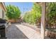 Well-manicured backyard featuring a brick paved patio, mature trees, flowers, and barbecue area at 7119 Saddle Back Peak St, Las Vegas, NV 89166