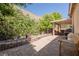 Beautiful landscaped backyard with a large brick paved patio, green foliage, flowers and seating at 7119 Saddle Back Peak St, Las Vegas, NV 89166