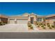 Lovely single-level home featuring a three-car garage, stone detailing, and xeriscaped front yard for water conservation at 7119 Saddle Back Peak St, Las Vegas, NV 89166