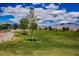 Serene view of a community park with lush green space, trees, playground, and distant mountain views at 7119 Saddle Back Peak St, Las Vegas, NV 89166
