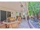 Open covered patio with brick flooring, a dining table, lounge chairs and access to the backyard at 7119 Saddle Back Peak St, Las Vegas, NV 89166