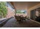 Relaxing covered patio with stone floors, a dining table, and an area for outdoor entertaining at 7119 Saddle Back Peak St, Las Vegas, NV 89166