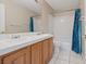 Bathroom featuring a double sink vanity, a tiled countertop, and a shower with a tiled tub at 7711 Lofty Hill Ct, Las Vegas, NV 89123