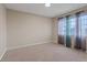 Bedroom with neutral walls, a large window with privacy curtains, and plush carpeting at 7711 Lofty Hill Ct, Las Vegas, NV 89123