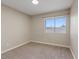 Bedroom featuring neutral walls and trim, a large window with backyard views, and plush carpeting at 7711 Lofty Hill Ct, Las Vegas, NV 89123