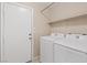 Laundry room featuring a washer, dryer, and storage shelves at 7711 Lofty Hill Ct, Las Vegas, NV 89123