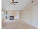 Carpeted living room features a fireplace, a ceiling fan, and large windows at 7711 Lofty Hill Ct, Las Vegas, NV 89123