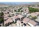 A sprawling suburban neighborhood with a backdrop of majestic mountains, featuring terracotta rooftops and lush landscaping at 1024 Larkspur Point Ct, Las Vegas, NV 89138