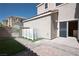 An outdoor patio area with brick pavers, artificial turf, and a white privacy screen with a sliding door into the home at 1024 Larkspur Point Ct, Las Vegas, NV 89138