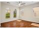 Bright bedroom features wood floors, ceiling fan, and many windows for natural light at 1024 Larkspur Point Ct, Las Vegas, NV 89138