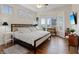 Main bedroom with hardwood floors, comfortable bed, bright natural light, and modern furniture at 11013 Mission Lakes Ave, Las Vegas, NV 89134
