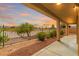 Inviting outdoor space featuring a covered patio with view of the desert landscape and sunset sky at 1172 Via Della Costrella, Henderson, NV 89011