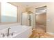 Bathroom featuring a soaking tub, separate shower, and frosted window for added privacy and natural lighting at 1172 Via Della Costrella, Henderson, NV 89011