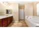 Well-lit bathroom showcases double sinks, a soaking tub, and a separate shower for relaxation and convenience at 1172 Via Della Costrella, Henderson, NV 89011
