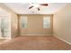 Large bedroom featuring neutral tones, carpet floors, a ceiling fan, and two windows at 1172 Via Della Costrella, Henderson, NV 89011