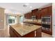 Large kitchen island with granite countertops and stainless appliances at 1172 Via Della Costrella, Henderson, NV 89011