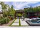 Serene backyard featuring a pool, multiple seating areas, lush landscaping, and a charming pergola for outdoor dining and relaxation at 12119 Castilla Rain Ave, Las Vegas, NV 89138