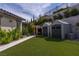 Landscaped backyard with artificial turf, storage sheds, and a charming barrel sauna at 12119 Castilla Rain Ave, Las Vegas, NV 89138