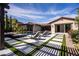 Expansive backyard showcasing a modern pool, lounge chairs, manicured landscaping, and a covered patio for ultimate outdoor living at 12119 Castilla Rain Ave, Las Vegas, NV 89138