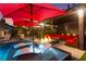Luxurious backyard pool with lounge chairs, fire pit, and comfortable seating area under a covered pergola at 12119 Castilla Rain Ave, Las Vegas, NV 89138