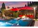 Backyard pool and spa with poolside seating area, fire pit, and beautiful landscaping under a colorful sunset at 12119 Castilla Rain Ave, Las Vegas, NV 89138