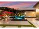 Backyard pool and spa, fire pit and covered patio, trees and landscaping under a colorful evening sky at 12119 Castilla Rain Ave, Las Vegas, NV 89138