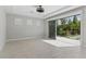 A bright bonus room with tile floors and an open sliding door to lush greenery and manicured landscaping at 12119 Castilla Rain Ave, Las Vegas, NV 89138