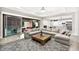 Bright living room featuring a large sectional sofa, fireplace, and seamless indoor-outdoor flow to the patio at 12119 Castilla Rain Ave, Las Vegas, NV 89138