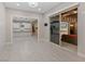 Open living space with tile floors leading to a modern kitchen and an outdoor patio at 12119 Castilla Rain Ave, Las Vegas, NV 89138