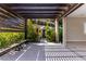 Covered patio with bench seating, wooden pergola, and large sliding glass doors for indoor/outdoor living at 12119 Castilla Rain Ave, Las Vegas, NV 89138
