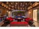 Covered outdoor patio with elegant lighting, red seating, and a view of the pool area at 12119 Castilla Rain Ave, Las Vegas, NV 89138
