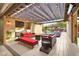 A covered patio features plush seating, a full outdoor kitchen, and scenic pool views at 12119 Castilla Rain Ave, Las Vegas, NV 89138
