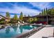 Stunning pool area features multiple seating areas, lush landscaping, and a cozy cabana with outdoor seating and fire feature at 12119 Castilla Rain Ave, Las Vegas, NV 89138