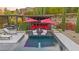 Backyard with sparkling pool, lounge chairs, covered seating with fire pit, and landscaped surroundings at 12119 Castilla Rain Ave, Las Vegas, NV 89138