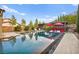 Stunning pool with modern design, lounge chairs, red umbrellas and pergola for stylish outdoor living at 12119 Castilla Rain Ave, Las Vegas, NV 89138