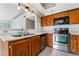 Kitchen area with wood cabinets, stainless steel appliances and double sink basin at 1575 W Warm Springs Rd # 121, Henderson, NV 89014