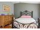 Comfortable bedroom featuring an ornate wrought iron bed frame, dresser, and neutral decor at 2137 Point Mallard Dr, Henderson, NV 89012