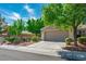 Quaint single-level home boasts a two-car garage, mature trees, and tidy landscaping for a welcoming curb appeal at 2137 Point Mallard Dr, Henderson, NV 89012